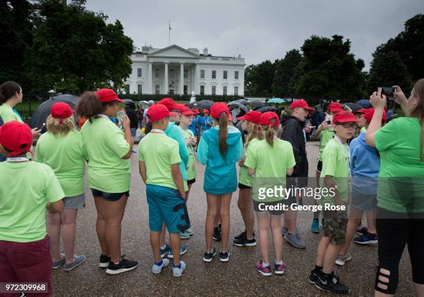 Group of school kids take pictures on the mall in front of The White House in the pouring rain on June 3, 2018 in Washington, D.C. The nation's...