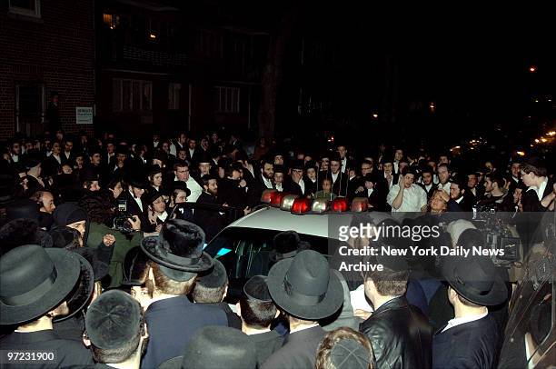 Angry Hasidim surround a police cruiser along 16th Ave. In the Borough Park section of Brooklyn following claims cops roughed up an elderly man when...