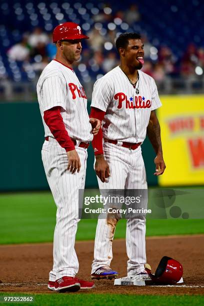 Nick Williams of the Philadelphia Phillies stands on the bag with third base coach Dusty Wathan against the Milwaukee Brewers during the seventh...