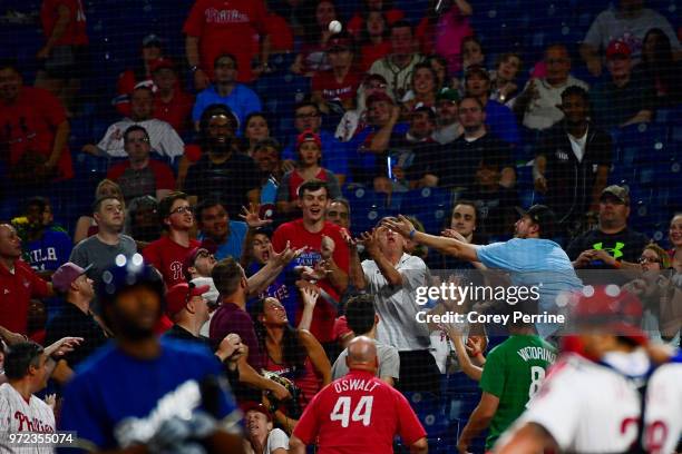 Fans scramble to catch a foul ball between the Philadelphia Phillies and the Milwaukee Brewers at Citizens Bank Park on June 8, 2018 in Philadelphia,...