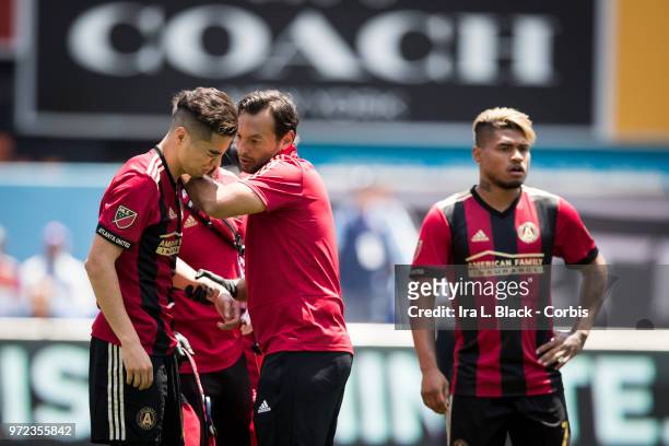Miguel Almiron of Atlanta United shows the pain while he is attended to after a injury to his shoulder during the MLS match between New York City FC...