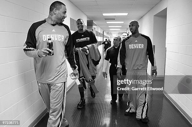 Kenyon Martin, Carmelo Anthony, strength and conditioning coach Steve Hess and Chauncey Billups of the Denver Nuggets walk through the hallway before...