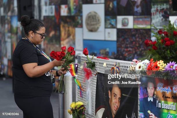 Bianca Booker places flowers on a fence at the memorial set up for the shooting victims at Pulse nightclub where the shootings took place two years...