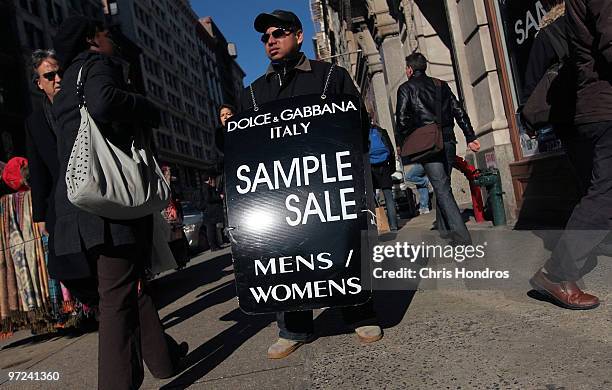 Worker carries a sandwich board advertising a sale in the SoHo shopping district of Manhattan March 1, 2010 in New York City. Consumer spending...