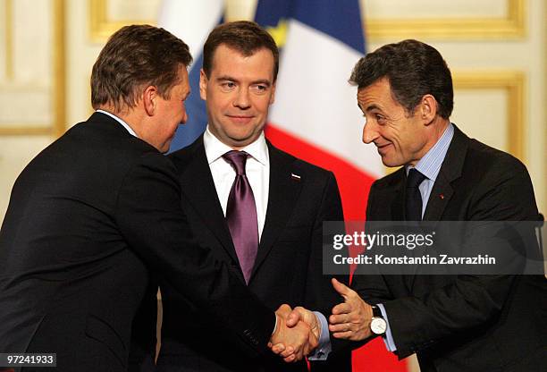 France's President Nicolas Sarkozy shakes hands with head of Russian Gazprom State Company Alexei Miller , watched by Russian President Dmitry...