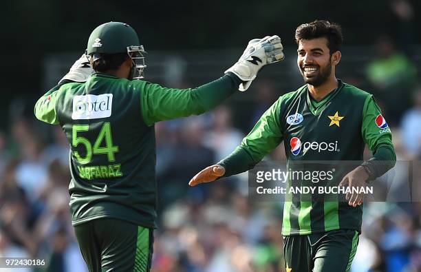 Pakistan's Shadab Khan celebrates with Pakistan's Sarfraz Ahmed after taking the wicket of Scotland's Calum MacLeod during the first Twenty20...