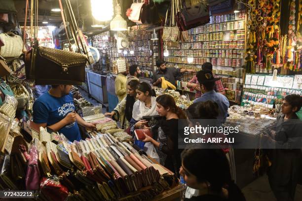 Pakistani residents shop at a market during holy month of Ramadan in Lahore on June 12, 2018. - Muslims around the world are preparing to celebrate...