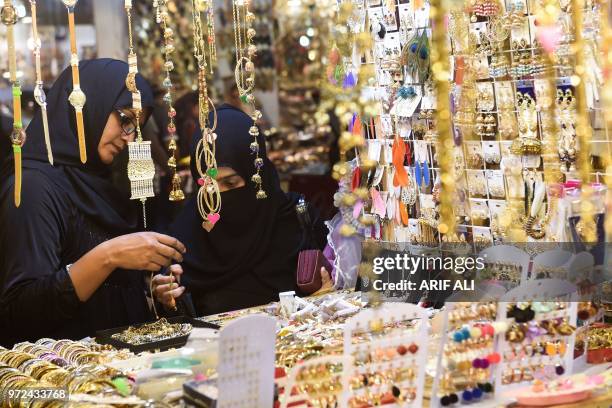 Pakistani residents shop at a market during holy month of Ramadan in Lahore on June 12, 2018. - Muslims around the world are preparing to celebrate...