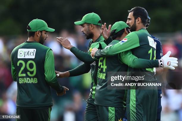 Pakistan's Sarfraz Ahmed celebrates with Pakistan's Shoaib Malik and Pakistan's Shadab Khan following the first Twenty20 International cricket match...