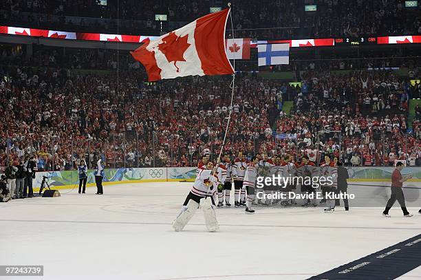 Winter Olympics: Canada goalie Roberto Luongo victorious with flag after Sidney Crosby won game by scoring overtime goal vs USA during Men's Gold...