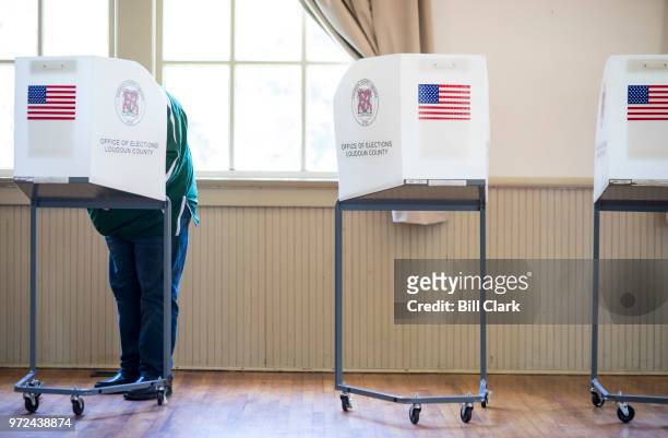 Voter casts his vote at the Hillsboro Old Stone School in Virginia's 10th Congressional district, Rep. Barbara Comstock's district, on primary...