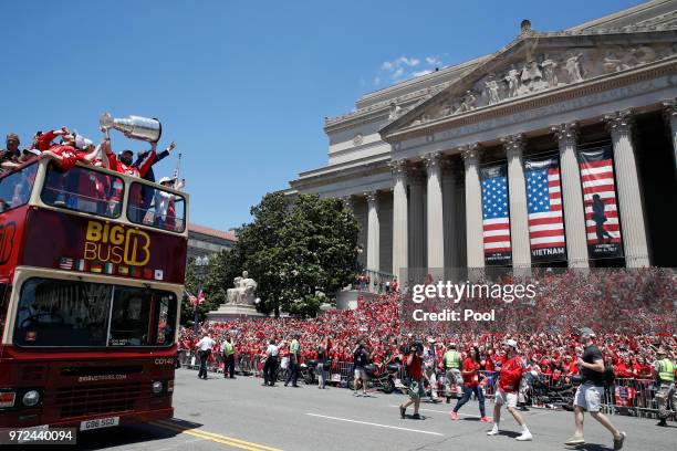 Washington Capitals left wing Alex Ovechkin , from Russia, holds up the Stanley Cup as they pass the crowd on the steps of The National Archives...