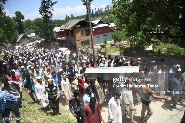 People carry the body of policeman Ghulam Hassan Wagay during his funeral at Vohlutra Rafiabad on June 12, 2018 in Baramulla, India. Wagay along with...