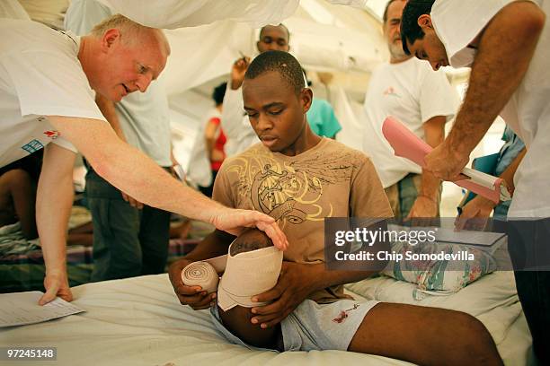 Frisnel Jeune has his stump examined by doctors and Handicap International physical therapist Luc Clerbaux in a tent on the grounds of the new...