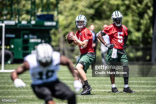 Quarterback Sam Darnold of the New York Jets works out during passing drills as quarterback Teddy Bridgewater of the New York Jets looks on at...