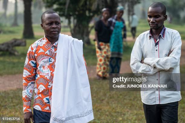 Father Lucien Ambunga, a Catholic priest who survived the Ebola virus , walks with Jimmy Bolongain , a health worker who as well survived Ebola, in...