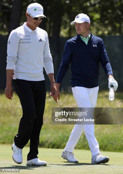 Haotong Li of China and Jordan Spieth of the United States walk on the second green during a practice round prior to the 2018 U.S. Open at Shinnecock...
