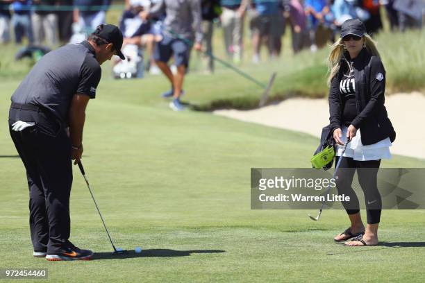 Patrick Reed of the United States putts as his wife Justine Karain looks on during a practice round prior to the 2018 U.S. Open at Shinnecock Hills...