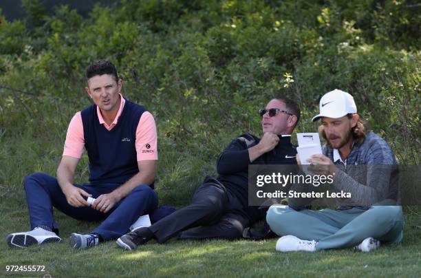 Justin Rose of England, golf instructor Sean Foley and Tommy Fleetwood of England sit together near the second tee during a practice round prior to...