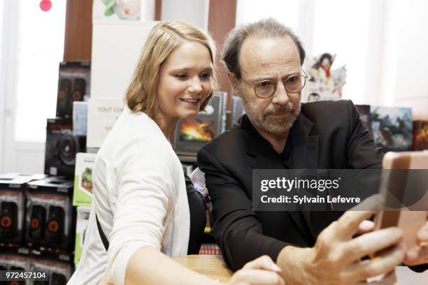 French writer Marc Levy poses for selfie with a fan as he attends a book signing at Furet du Nord on June 12, 2018 in Lille, France.