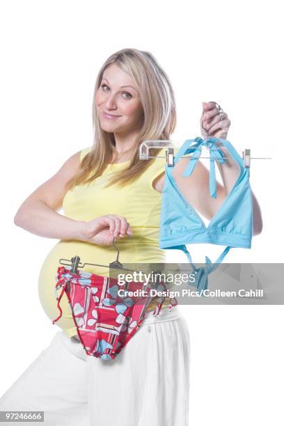 pregnant woman holding bikini - skimpy bathing suits stock pictures, royalty-free photos & images