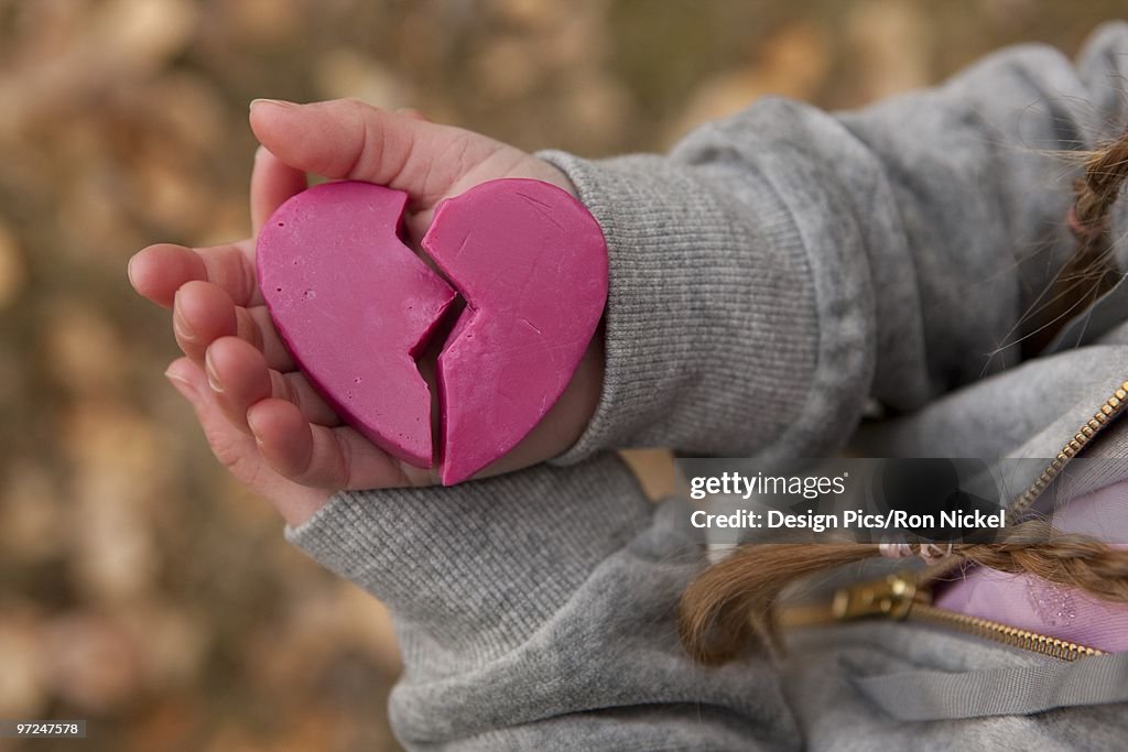 Girl holding broken heart
