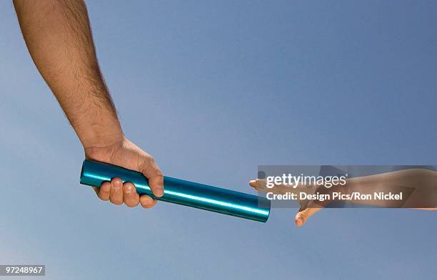 father handing off a baton to his son - family relay stock pictures, royalty-free photos & images