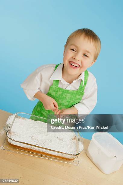 boy icing a cake - flour sifter stock pictures, royalty-free photos & images