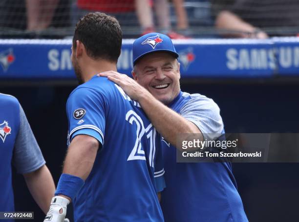 Luke Maile of the Toronto Blue Jays is congratulated by manager John Gibbons after drawing a game-winning RBI walk with the bases loaded in the tenth...