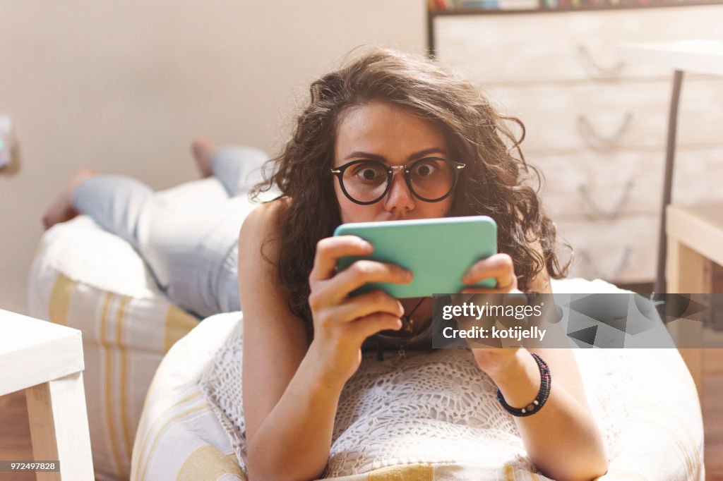 Mujer usando el teléfono en su casa
