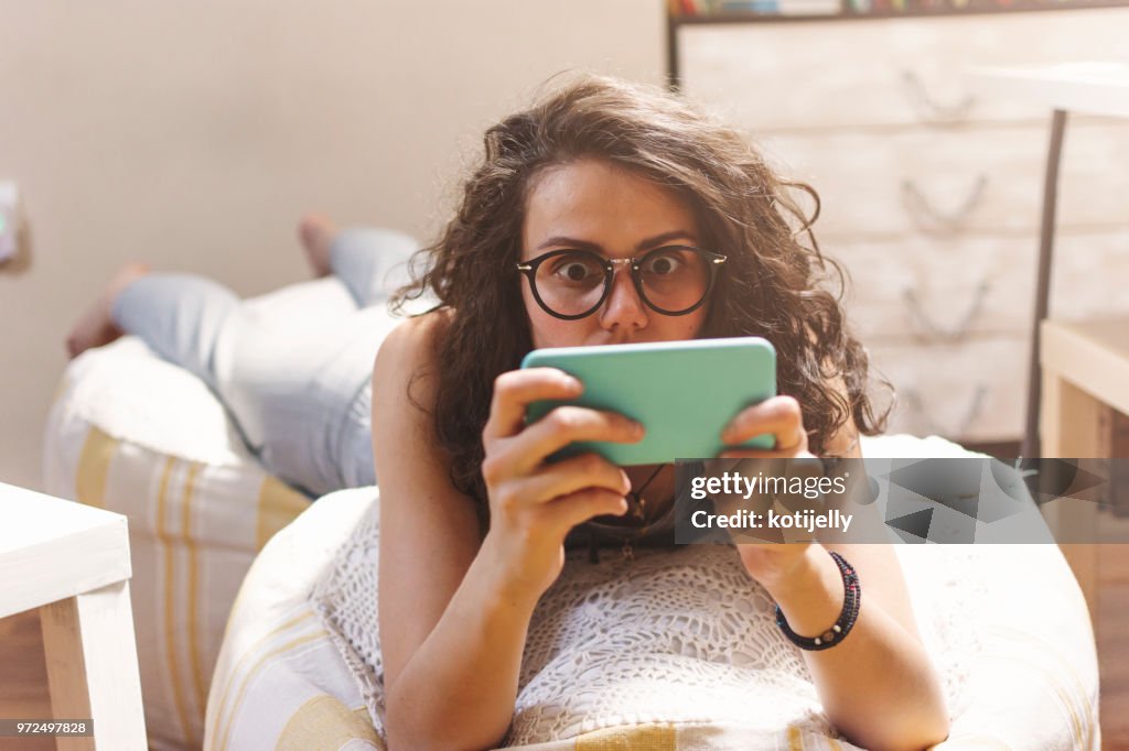 Vrouw met behulp van telefoon thuis