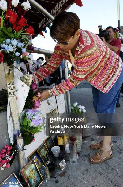 Anna Brady places flowers at the spot where her mother, Rachel Paliseno, was stabbed to death by a purse snatcher while walking to a grocery store...