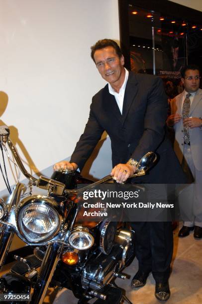 Arnold Schwarzenegger shows off an Indian Chief T3 limited edition motorcycle during the grand opening of Audemars Piguet's new flagship store on E....