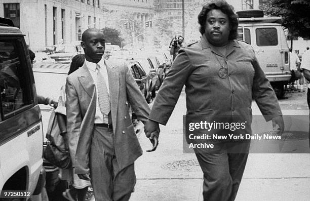 Anton McCray, accused of raping and beating a Central Park jogger, walks to court with the Rev. Al Sharpton.