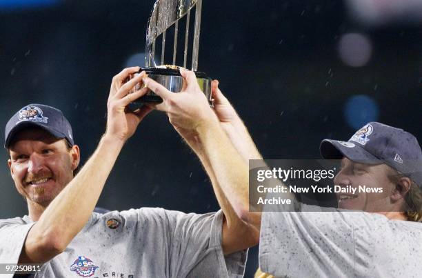 Arizona Diamondbacks' pitchers Randy Johnson and Curt Schilling hold up trophy as they celebrate their 3-2 win over the New York Yankees in Game 7 of...