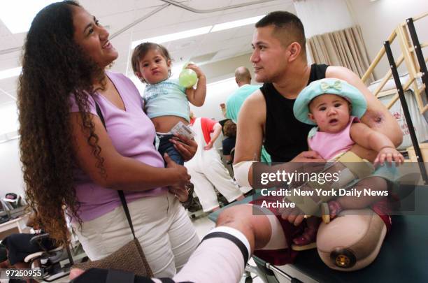 Army Sgt. Anesi Tuufuli, whose left leg was blown off on Feb. 25 by a massive C-4 bomb hidden in a palm tree trunk in Taji, Iraq, enjoys a visit from...