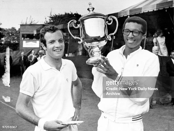 Arthur Ashe holds trophy after defeating Tom Okker , of the Netherlands, to win the U.S. Open at Forest Hills. The first African-American to play on...