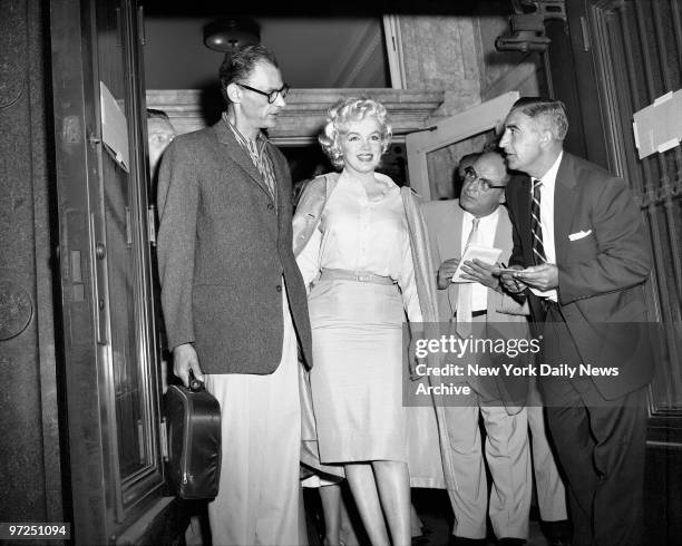 Arthur Miller, the playwright, accompanies his wife, Marilyn Monroe, as they drive away from Lenox HIll Hospital. The dazzling film star was...