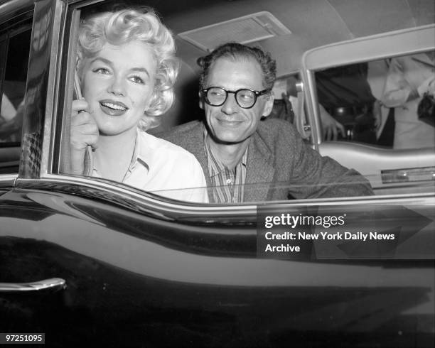 Arthur Miller, the playwright, gazes' adoringly at his wife, Marilyn Monroe, as they drive away from Lenox HIll Hospital. The dazzling film star was...