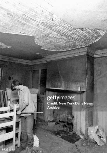 Edith Bouvier Beale house in East Hampton, L.I. Workman is oblivious to unplastered dining room ceiling..