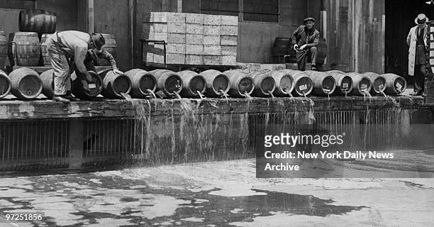 At an army base in Brooklyn, men drain 10,000 barrels of beer into New York Harbor during Prohibition.
