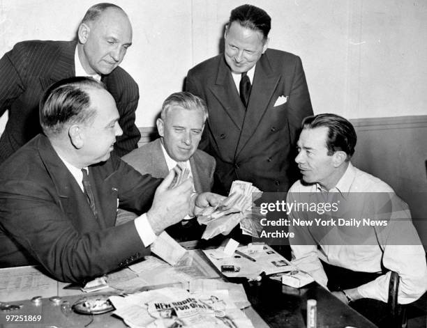 At Brooklyn Police Headquarters, Police Commissioner Manoghan holds money taken from Willie Sutton , as Chief Inspector Conrad Rothengast, Brooklyn...