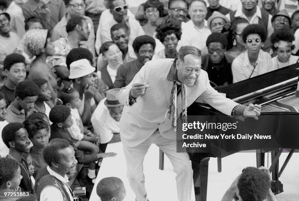 Duke Ellington leans forward to greet a fan while conducting his band during concert on 129th St. Edward Kennedy Ellington, born in 1899 in...