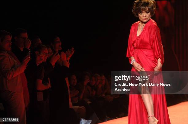 Audience members scream, clap and snap photos as the legendary Eartha Kitt clad in a crimson Kai Milla gown, shows off her enviable legs during the...