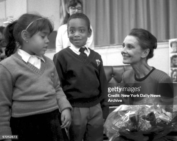 Audrey Hepburn accepts flowers from Christina Campos and Preston Jackson at St. Catherine of Sienna School.