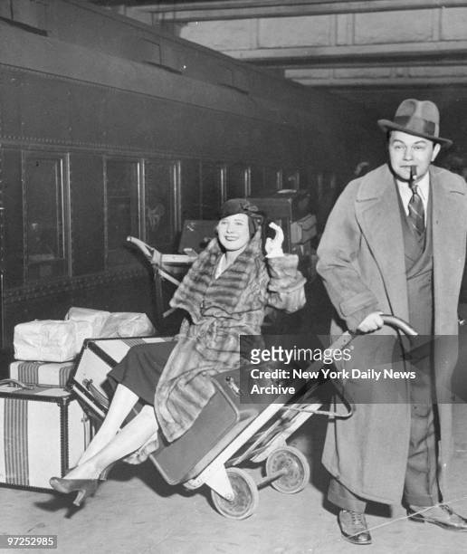 Edward G. Robinson gives actress Marilyn Miller a lift with the luggage at Grand Central Terminal.