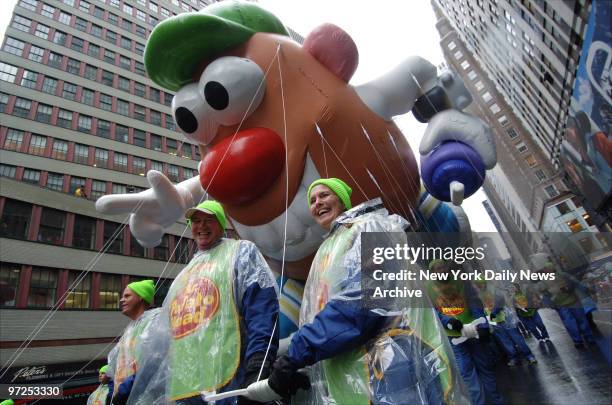 Handlers maneuver the Mr. Potato Head balloon down Broadway during the 80th annual Macy's Thanksgiving Day Parade. Despite gusty winds and...