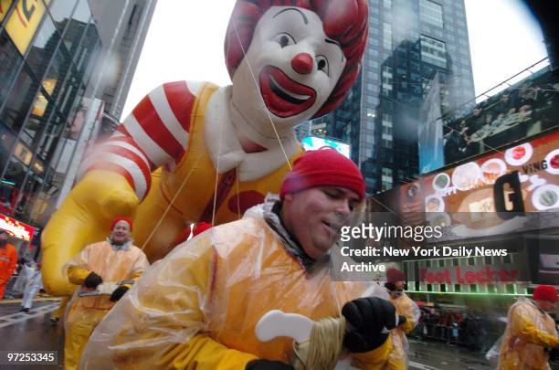 Handlers maneuver the Ronald McDonald balloon through Times Square during the 80th annual Macy's Thanksgiving Day Parade. Despite gusty winds and...