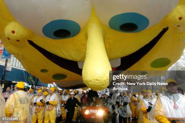 Handlers maneuver the SpongeBob SquarePants balloon down Central Park West during the 80th annual Macy's Thanksgiving Day Parade. Despite gusty winds...