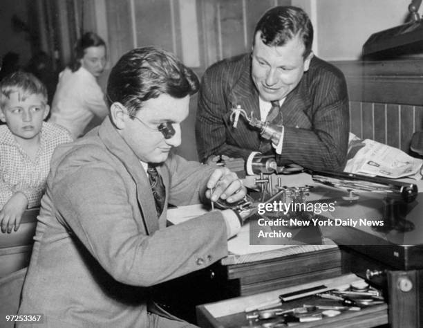 Handless Navy vet Ralph Padavano and actor Harold Russell, go over watch repairing gadgets invented by Ralph, at Bellevue Hospital.